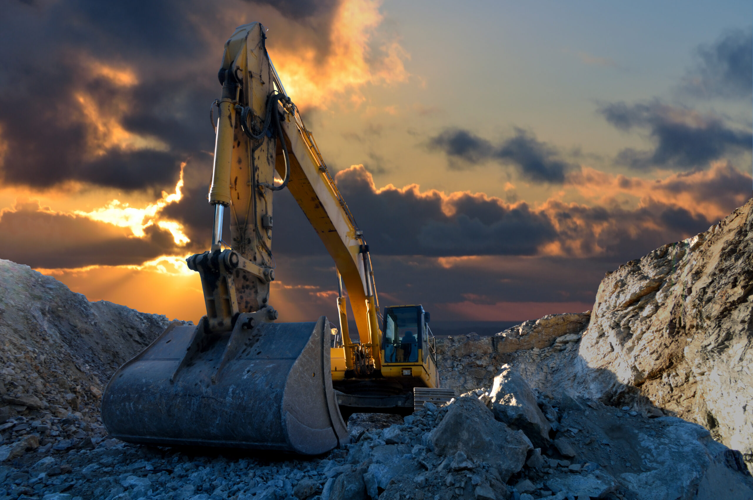 HME International - Heavy Mining Equipment Solutions tracked excavator in a quarry with a setting sun and light rays